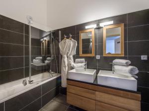 a bathroom with two sinks and a tub and mirror at Appartement Courchevel 1650, 5 pièces, 8 personnes - FR-1-563-29 in Courchevel