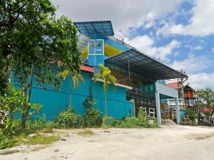 a blue building with a person on top of it at OYO 90492 Papi Inn Guesthouse in Palangkaraya