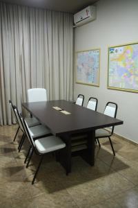a conference room with a black table and chairs at Hotel Mirage in Vilhena
