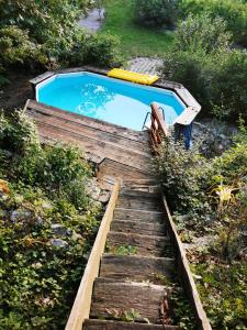 a wooden stairs leading up to a swimming pool at Krasberry Ježev brlog in Komen
