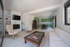 a living room with a couch and a table at Eucalyptus -- Agios Ioannis Beachfront Apartment in Lefkada Town +10 photos