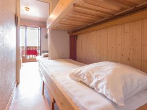 a bed in a room with a wooden wall at Studio La Rosière, 1 pièce, 4 personnes - FR-1-275-144 in La Rosière