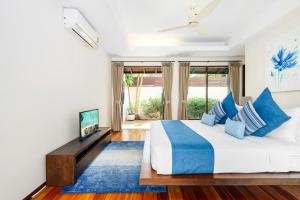 1 dormitorio con 1 cama grande con almohadas azules en Bacaya Beachfront Villa, en Bangrak Beach