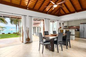 cocina abierta y comedor con mesa y sillas en Bacaya Beachfront Villa, en Bangrak Beach