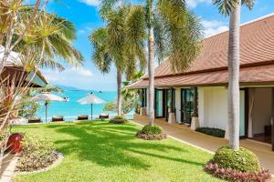 a resort with palm trees and the ocean in the background at Bacaya Beachfront Villa in Bang Rak Beach