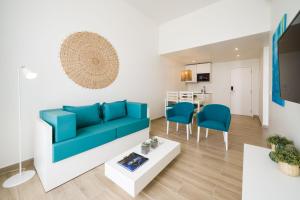 a living room with a blue couch and a table at Oasis Tarrafal Alfandega Suites in Tarrafal