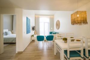een kamer met een bed en een tafel en stoelen bij Oasis Tarrafal Alfandega Suites in Tarrafal