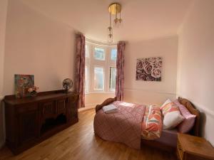 um quarto com uma cama, uma mesa e uma janela em Spacious 3BR, town centre, 8 min walk to beach em Bournemouth