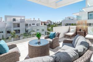 d'une terrasse avec des canapés et une table sur un balcon. dans l'établissement CDG- Cortijos Del Golf by Roomservices, à Estepona