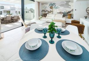 een eetkamer met een witte tafel met blauwe gerechten erop bij CDG- Cortijos Del Golf by Roomservices in Estepona