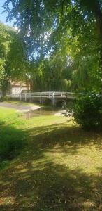 eine Brücke in einem Park mit Bäumen und Gras in der Unterkunft Coatham Cottage in Barton