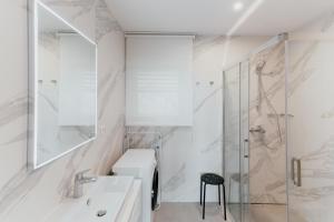 a white bathroom with a sink and a shower at Carmen Residence Apartments in Opatija