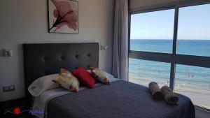 sypialnia z łóżkiem i widokiem na plażę w obiekcie MarMédano Apartamento 3 w mieście El Médano