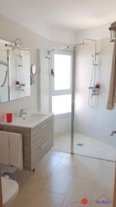 biała łazienka z umywalką i prysznicem w obiekcie MarMédano Apartamento 3 w mieście El Médano
