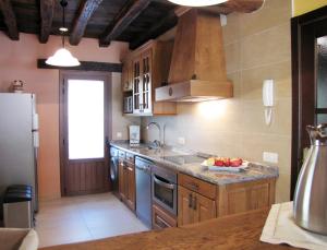 Una cocina con gabinetes de madera y encimera. en Sagardikoetxea II, en Oskotz