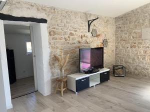 Televízia a/alebo spoločenská miestnosť v ubytovaní Maison charentaise pleine de charme