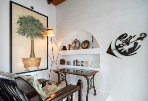 Finca Isolina Hotel Boutique - Adults Recommended في Mácher: غرفة معيشة مع طاولة ونبات على الحائط