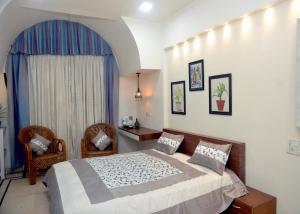 a bedroom with a bed and two chairs at Paradise Homestay Civil Lines in Nagpur