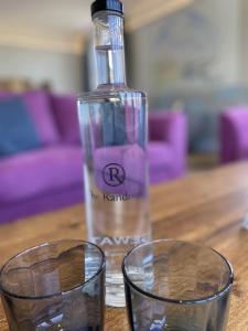 a bottle and two glasses on a wooden table at The Randolph Hotel in Southwold