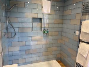 a bathroom with a shower with a glass door at The Randolph Hotel in Southwold
