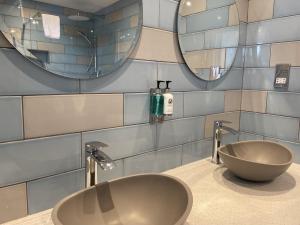 a bathroom with a sink and two mirrors at The Randolph Hotel in Southwold