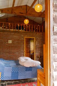 a bedroom with a bed in a brick wall at Seegreen Lodges in Mussoorie