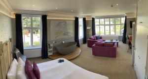 a bedroom with a bed and a living room at The Randolph Hotel in Southwold