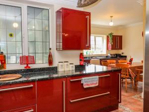 a kitchen with red cabinets and a dining room at The Orchard in Rye