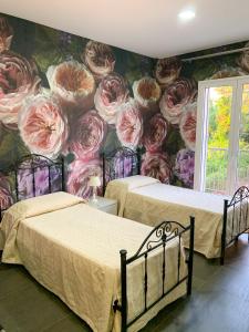 1 dormitorio con 2 camas y un mural de rosas en Bla Bla B&B, en Taurianova