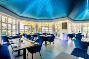 ein Restaurant mit blauen Decken, Tischen und Stühlen in der Unterkunft Yachthotel Chiemsee GmbH in Prien am Chiemsee