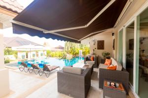 a patio with chairs and a swimming pool at Hua Hin Horizon in Hua Hin