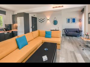a living room with a orange couch and blue pillows at LUNAR in Skala Rachoniou
