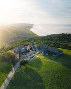 an aerial view of a house on a hill next to the ocean at Simbavati Fynbos on Sea Cottage in Sedgefield