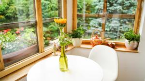 una mesa con dos sillas y un jarrón con flores. en CHATA U VINCENTA s fínskou saunou a altánkom en Hnilčík