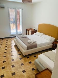 1 Schlafzimmer mit 2 Betten und Holzboden in der Unterkunft Bonorum Santa Sofia in Palermo