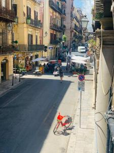 ein rotes Fahrrad, das an der Straßenseite geparkt ist in der Unterkunft Bonorum Santa Sofia in Palermo
