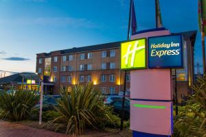 um sinal para uma estalagem de férias expresso em frente a um edifício em Holiday Inn Express Cardiff Bay, an IHG Hotel em Cardiff