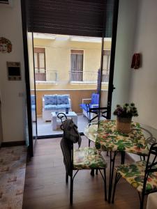 Zimmer mit einem Tisch und Stühlen sowie einem Wohnzimmer in der Unterkunft La dimora di Enrico in Catania