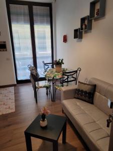 ein Wohnzimmer mit einem Sofa und einem Tisch in der Unterkunft La dimora di Enrico in Catania