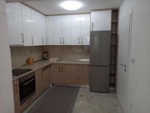 a kitchen with white cabinets and a refrigerator at Apartment Ilidza-SK in Sarajevo