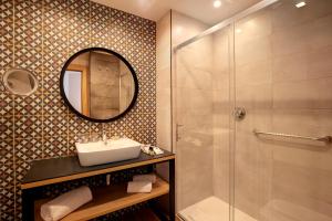 a bathroom with a sink and a shower with a mirror at Catalonia Excelsior in Valencia