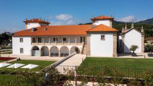 un grand bâtiment blanc avec un toit orange dans l'établissement Solar do Requeijo by Luna Hotels & Resorts, à Arcos de Valdevez