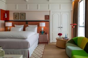 1 dormitorio con 1 cama blanca grande y 1 sofá en Sinner Paris en París