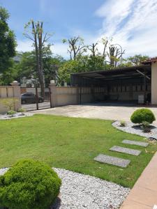 une cour avec de l'herbe et des pierres devant un bâtiment dans l'établissement Airport Garden Stay #corner hoise 5 rooms #free wifi #parking #tv chanel, à Shah Alam