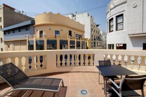 a balcony with a table and chairs and a building at Catalonia Excelsior in Valencia