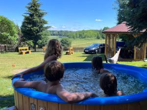 a group of people sitting in a hot tub at KrzyweProgi - domek na Mazurach nad jeziorem Krzywe in Langendorf