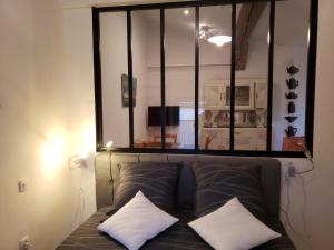 a mirror above a bed with two pillows on it at le balcon in Camps-sur-lʼAgly