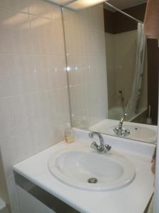 y baño con lavabo blanco y espejo. en Aux Fontaines Honfleur, en Honfleur