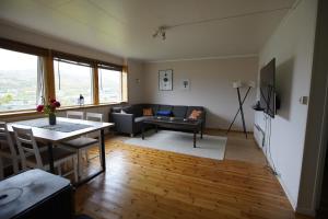 a living room with a couch and a table at Havøysund house with a beautiful view in Måsøy