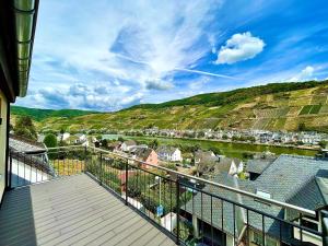 a balcony with a view of a town and a river at Sky Apartment, Sauna, Blick zur Mosel, großer Balkon, Kaffeemaschine, Smart TV in Zell an der Mosel +17 photos